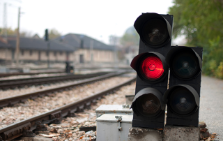 Red railway signal beside train tracks at a station or rail yard