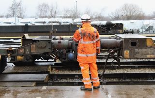 Rail worker in orange high-visibility clothing inspecting