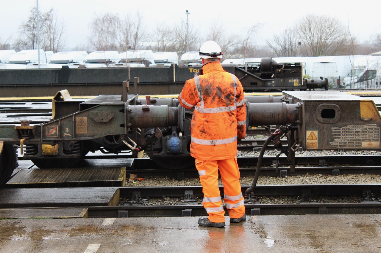 Rail worker in orange high-visibility clothing inspecting